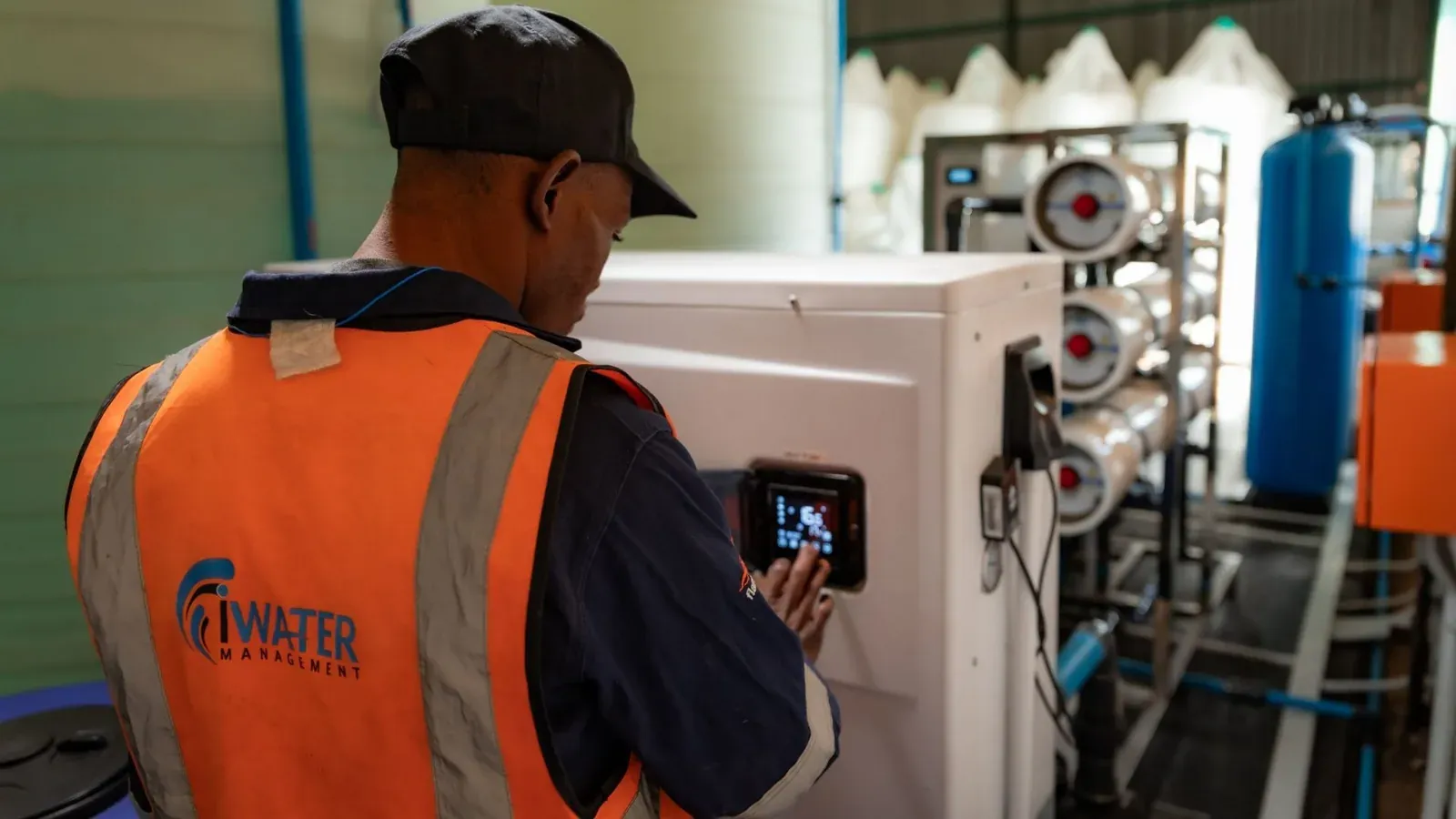 iWater Management technician working on a reverse osmosis water treatment plant during a maintenance service call.