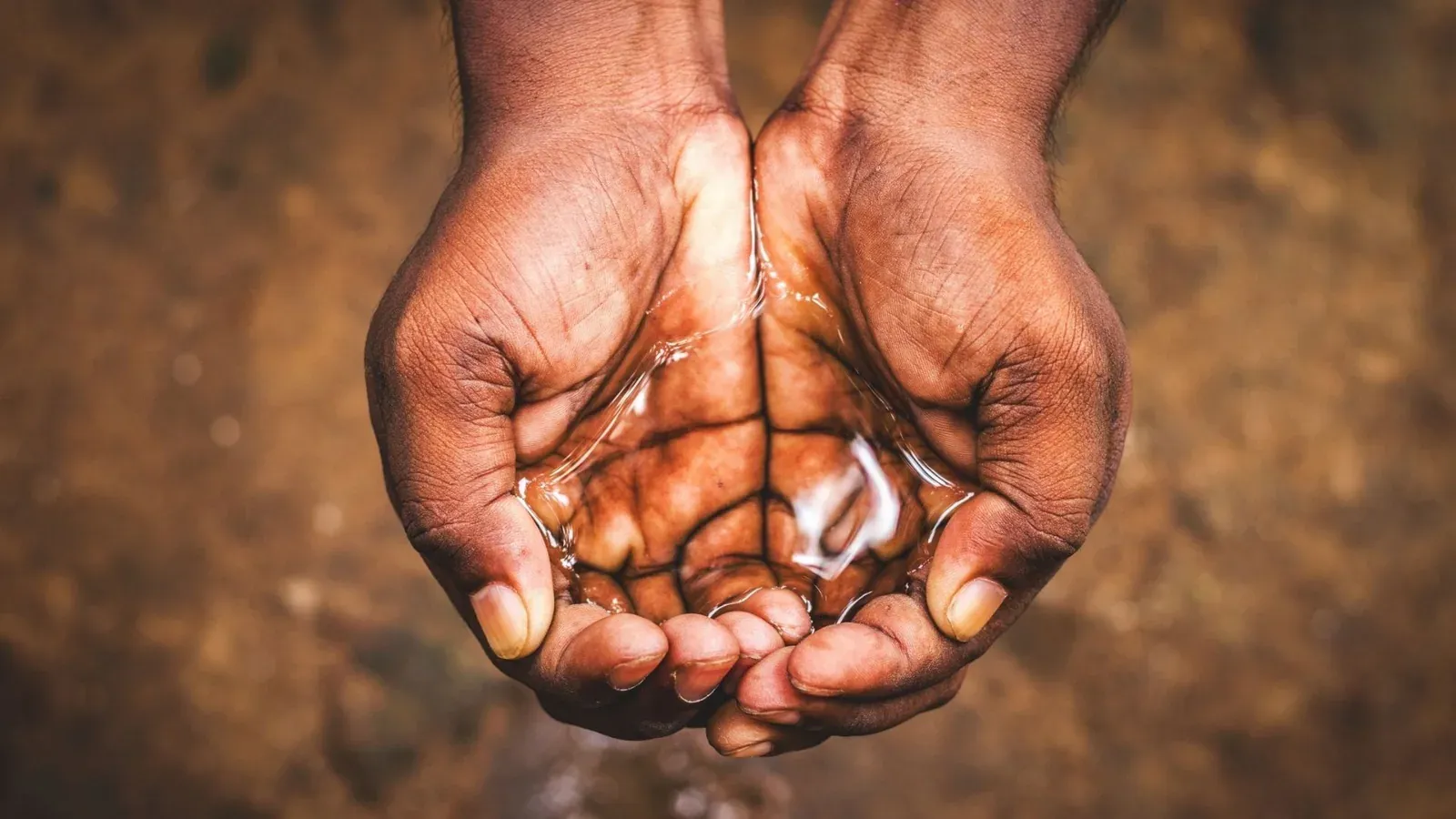 Hands cupped under running water during a Johannesburg water crisis, highlighting the urgency of reliable water supply and fair billing.