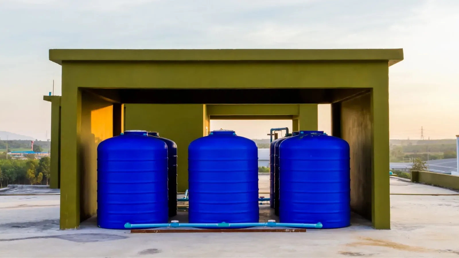 Blue water storage tanks on a rooftop in Cape Town, representing private water systems that require SANS 241 compliance testing.